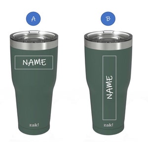 May include: Two green insulated tumblers with stainless steel lids. The tumblers have a white rectangle with the word "NAME" written inside. The tumblers are labeled "zak!" at the bottom.