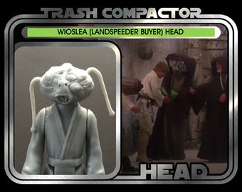 May include: Vintage action figure of Wioslea (Landspeeder Buyer) Head. The figure is light grey with two long, white antennae. The packaging includes the text "TRASH COMPACTOR" and "Ages 14 and up". The background shows a scene from a movie.