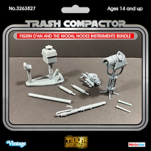 Puede incluir: Un conjunto de instrumentos Figrin D'an y Modal Nodes de Trash Compactor de plástico gris. El conjunto incluye varios modelos de instrumentos, como un soporte, un instrumento cilíndrico y otras piezas detalladas. El embalaje es de estilo vintage.