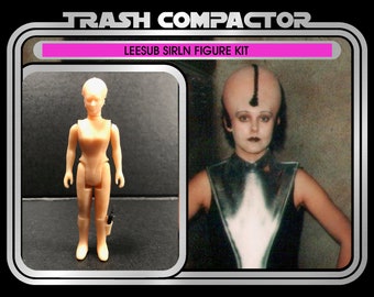 May include: A vintage action figure kit labeled "Trash Compactor" featuring a Leesub Sirln figure. The packaging includes a photo of the character and the text "Ages 14 and up." The figure is a light tan color and comes with a small accessory.