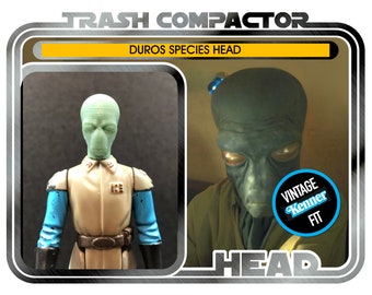May include: A vintage-style action figure package featuring a Duros species head. The package includes two images of the alien figure, one in a uniform. The text on the package reads "TRASH COMPACTOR" and "DUROS SPECIES HEAD."