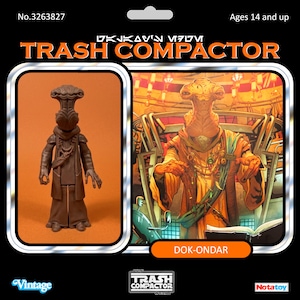 Peut inclure: Une figurine marron du personnage Dok-Ondar, présentée sur un support noir avec le texte TRASH COMPACTOR, No.3263827, Ages 14 and up, et DOK-ONDAR. La carte présente une illustration colorée du personnage dans un décor de boutique.