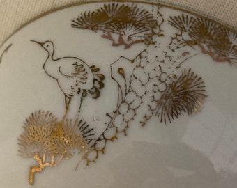 Chinese footed rice bowl decorated with gold birds in a garden