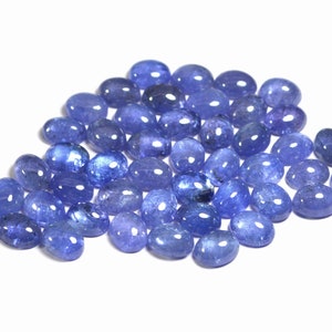 Group of oval blue-violet tanzanite cabochons, natural gemstones with smooth domed tops and flat-back cabochons for jewelry making.
