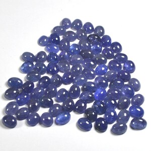 Group of oval blue-violet tanzanite cabochons, natural gemstones with smooth domed tops and flat-back cabochons for jewelry making.