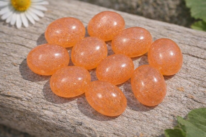 Peach moonstone cabochons, oval-shaped, smooth domed gemstones in peach color; ideal for jewelry making, 5x7–15x20 mm.