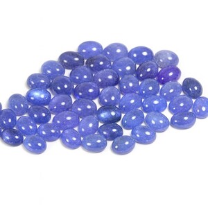 Group of oval blue-violet tanzanite cabochons, natural gemstones with smooth domed tops and flat-back cabochons for jewelry making.