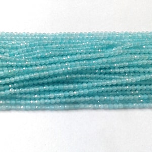 Könnte beinhalten: Eine Strähne aus hellblauen Edelsteinperlen. Die Perlen sind rund und haben eine glatte, polierte Oberfläche.