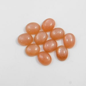 Peach moonstone cabochons, oval-shaped, smooth domed gemstones in peach color; ideal for jewelry making, 5x7–15x20 mm.