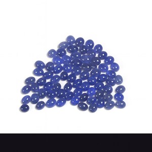 Group of oval blue-violet tanzanite cabochons, natural gemstones with smooth domed tops and flat-back cabochons for jewelry making.