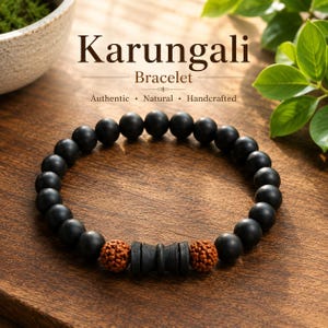 May include: A Karungali bracelet featuring matte black spherical beads arranged in a circular band. The design includes two textured brown spherical beads and a central black cylindrical spacer bead with a concave middle section.