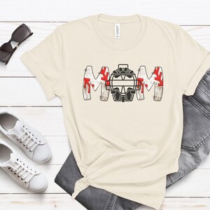 Baseball Shirt features distressed font spelling the word Mom and a Catcher's mask in place of the "o" in Mom.