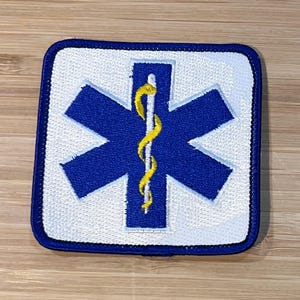 Op de afbeelding: Blauw en wit geborduurde patch met een ster van het leven en een caduceus symbool.