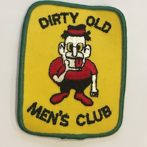Peut inclure: Un écusson brodé jaune avec une bordure verte. L'écusson représente un personnage de dessin animé portant une chemise rouge, un pantalon noir et un chapeau noir. Le texte "Dirty Old Men's Club" est brodé en noir.