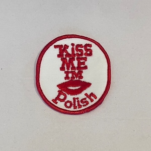 May include: Red embroidered patch with white background. The patch says "Kiss Me I'm Polish" with a red lipstick imprint.