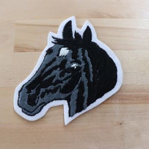 May include: Black and white embroidered horse head patch. The horse has a white star on its forehead.