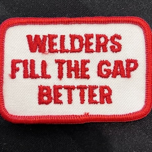 May include: Red embroidered patch with a white background. The text reads "Welders Fill the Gap Better".
