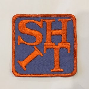 May include: Orange embroidered patch with the letters "SHT" in a blue square.
