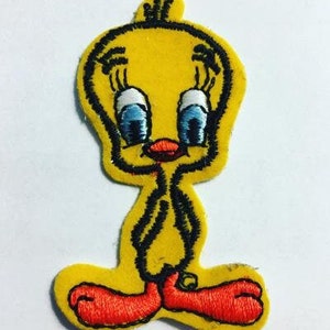 Può includere: Toppa ricamata gialla da stirare di Tweety Bird, un personaggio dei cartoni animati, con contorni neri e occhi blu.