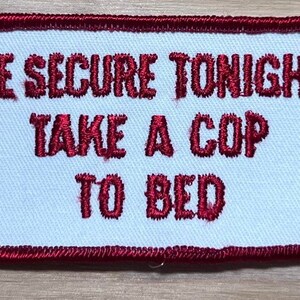 May include: Red embroidered patch with white background and the text "BE SECURE TONIGHT TAKE A COP TO BED".
