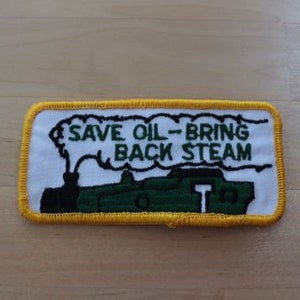 May include: A white and yellow embroidered patch with a green steam engine and the text "Save Oil - Bring Back Steam".