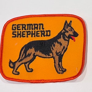 May include: Orange fabric patch with an embroidered black and brown German Shepherd dog and the text "GERMAN SHEPHERD".