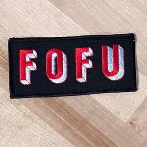 May include: Black embroidered patch with the word "FOFU" in white and red 3D lettering.