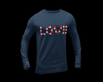May include: A navy blue long-sleeve shirt with the word "LOVE" in a pixelated design of red, white, and navy blue squares. The shirt has a crew neck and a fitted silhouette.