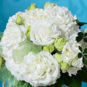 May include: A bouquet of white lisianthus flowers with green foliage and a white sheer ribbon.