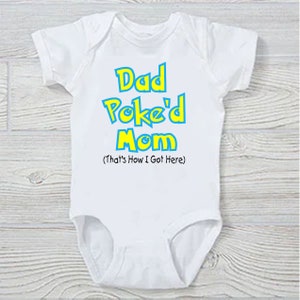 Pu&ograve; includere: Body bianco per neonato con testo blu e giallo che dice "Dad Poke'd Mom (That's How I Got Here)"