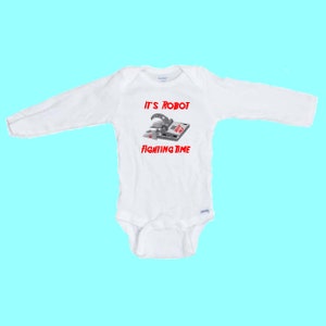 May include: White long-sleeved baby onesie with a grey robot trap and the text "It's Robot Fighting Time" in red.