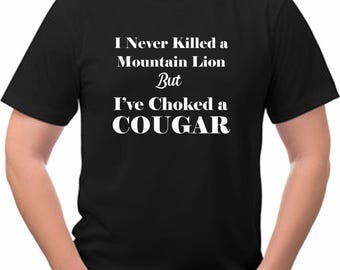 May include: A black t-shirt with white text that reads "I Never Killed a Mountain Lion But I've Choked a COUGAR".
