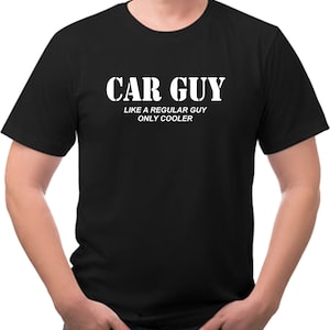 May include: Black t-shirt with white text that reads "CAR GUY LIKE A REGULAR GUY ONLY COOLER".