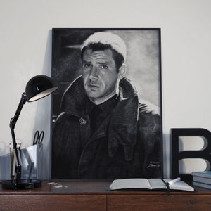 May include: Black and white portrait drawing of a man wearing a dark jacket with a high collar. The drawing is framed and hanging on a wall.