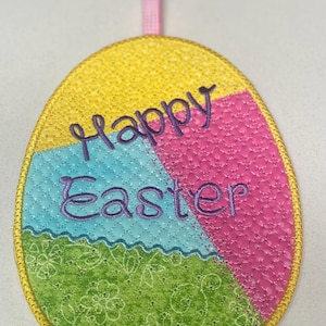 May include: A yellow, pink, blue, and green Easter egg ornament with the text "Happy Easter" embroidered in purple. The ornament has a gold trim and a pink ribbon for hanging.