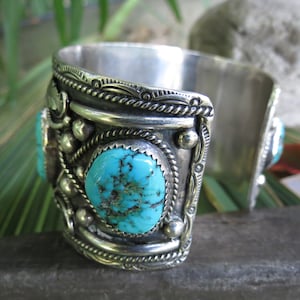 May include: Silver cuff bracelet with turquoise stones and intricate silver designs.