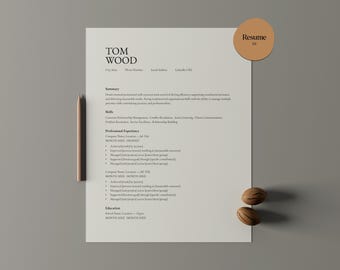 May include: A resume template with the name "TOM WOOD" at the top. The document includes sections for summary, skills, professional experience, and education. A wooden pencil and two decorative nuts are placed near the document. A circular sticker with the word "Resume" is on the top right.