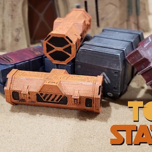 May include: A collection of four orange and grey painted miniature cargo containers. The containers are stacked on top of each other. The containers have a worn, distressed look. The text "TOS CHE STATION" is visible in the bottom right corner of the image.