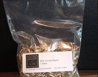 May include: A clear plastic bag filled with dried blue vervain herbs. The bag has a white label with the text "Blue vervain Organic" and "1 ounce". The label also includes the text "OLDE THYME APOTHECARY" and a phone number.