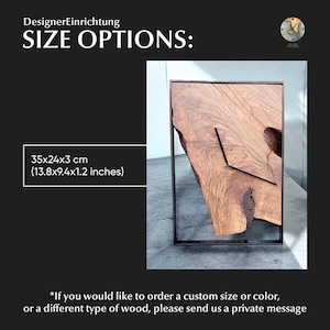 May include: A wooden clock with a natural wood finish and a black metal frame. The clock is 35 cm wide, 24 cm tall, and 3 cm deep. The clock is made of wood and has a natural wood finish. The clock has a black metal frame.