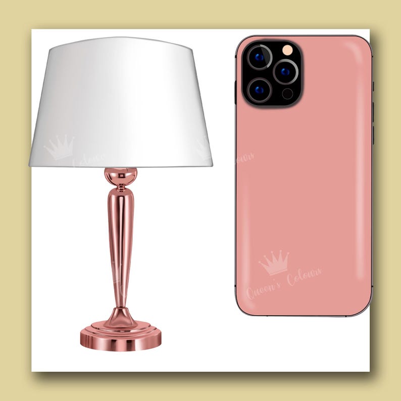 Op de afbeelding: Een roze gouden tafellamp met een witte lampenkap en een roze gouden iPhone-hoes met een kroonlogo en de tekst "Queen's Colors".
