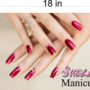 May include: Close-up of hands with long, red nails with rhinestones. The nails are done in a shellac manicure style. The text "Shellac Manicure" is in the lower right corner of the image.