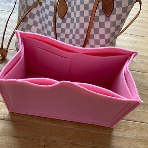 Könnte beinhalten: Rosa Filztasche Organizer mit mehreren Fächern und Taschen für eine Handtasche.