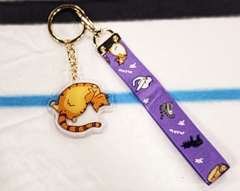 Llavero con forma de meme de gato morado y cordón de nailon