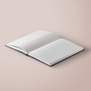 May include: An open notebook with lined pages and a black cover. The notebook is lying open on a light pink surface.