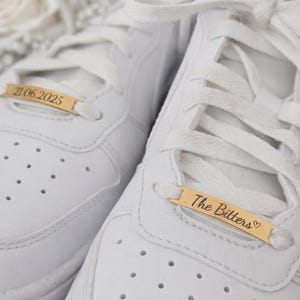 Detailaufnahme von Hochzeitssneakern mit gravierten Shoe Tags – elegantes Hochzeitsaccessoire aus Edelstahl