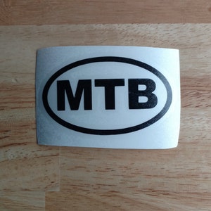 May include: A white oval sticker with a black outline and the word "MTB" in black letters.