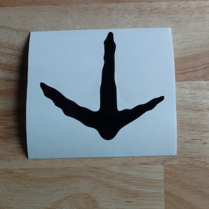 May include: Black vinyl sticker of a turkey track. The track is a silhouette of a turkey's foot with three toes and a back toe.