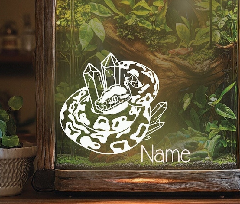 May include: White vinyl sticker of a snake curled around crystals. The snake has a black eye and a white background. The text "Name" is below the snake.