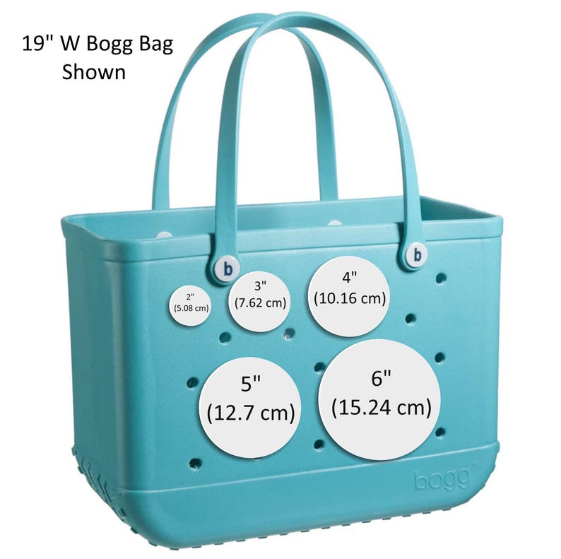 May include: A light blue Bogg Bag with a white label that says "bogg". The bag has four white circles with measurements in inches and centimeters. The bag has two handles.
